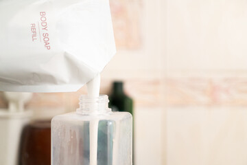 Refilling Body Soap from a Pouch. sustainability and eco friendliness in daily life, showing a simple act of reducing plastic waste by using refillable products.