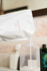 Refilling Body Soap from a Pouch. sustainability and eco friendliness in daily life, showing a simple act of reducing plastic waste by using refillable products.