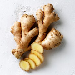 Fresh ginger root, whole and sliced, on a light background