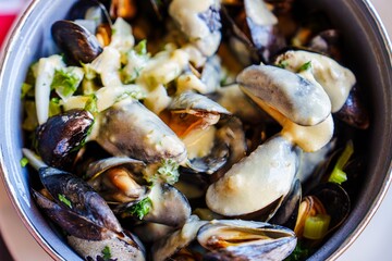 Savor the delightful moules Marinieres, featuring tender steamed mussels in a rich, aromatic sauce with fresh herbs and vegetables. A perfect dish for seafood lovers and gourmet dining.