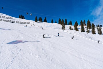 Experience the excitement of winter sports with this vibrant image of skiers navigating a snowy mountain under a clear blue sky, embodying adventure and the joy of outdoor activity.