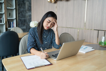 Burnout concept. Asian Business woman touching forehead having headache boring job and tired...