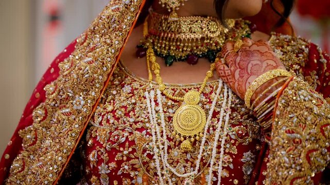 The bride is dressed in traditional red Asian clothes with beautiful neckless on her neck , Elements of Hindu wedding. Close up view.