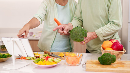 Asian Older Adult Couple Cooking Healthy Meal Home Kitchen Learning Recipe Digital Tablet Fresh Vegetables Food Preparation Wellness Seniors