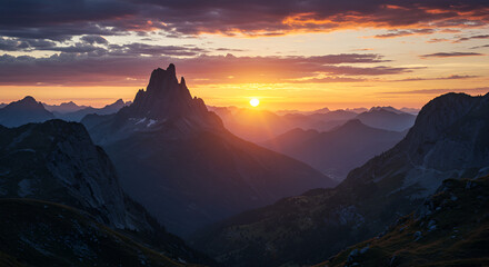 A Dramatic mountain sunrise casting golden light across deep valley peaks