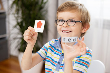 Smiling Child Learning Colors with Flashcards and Blocks