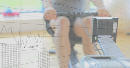 Adult male in sportswear pulling rowing handle on rail in fitness studio, with data graph overlay