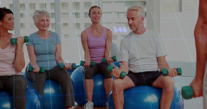 Smiling group in sportswear on blue stability balls lifting green dumbbells in gym, digital overlay