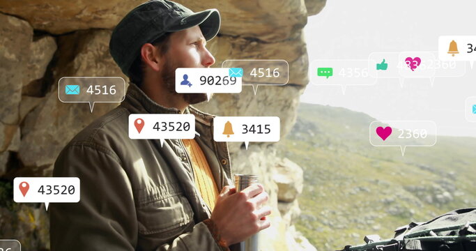 Gazing hiker wearing cap, field jacket at rocky overlook, holding flask and digital overlay icons