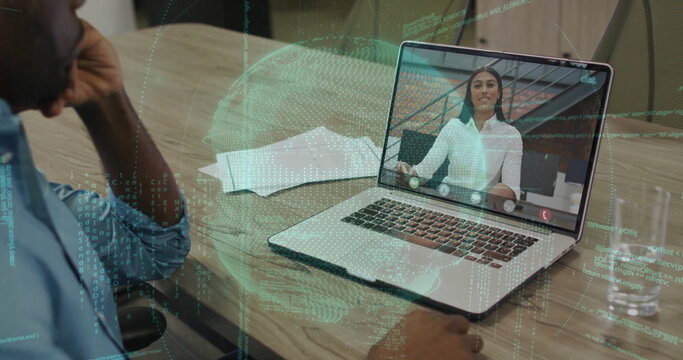 Man in blue shirt joining call on laptop at office, with papers, water glass, code overlay
