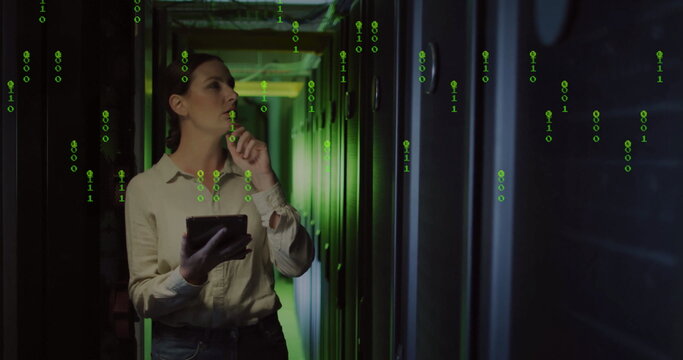 Analyzing IT engineer in jeans holding tablet in server corridor, with racks cables binary overlay - Powered by Adobe