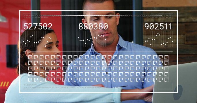 Two business professionals reviewing digital data overlay at modern office desk, with laptop screen - Powered by Adobe