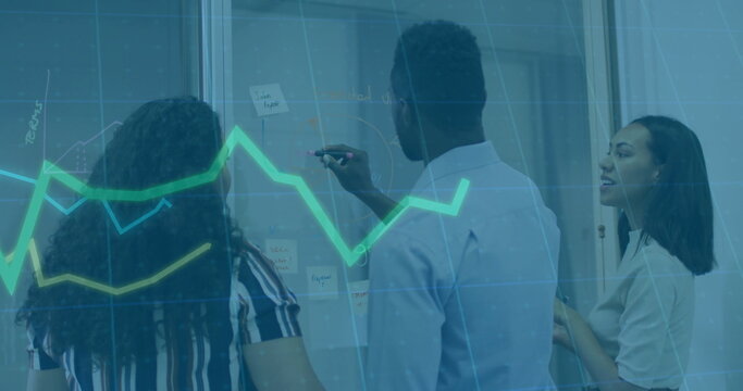 Discussing team of three wearing suits marking glass wall in office with sticky notes chart overlay