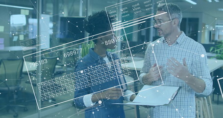 Colleagues in business attire reviewing floating data overlays in office, with tablet and clipboard