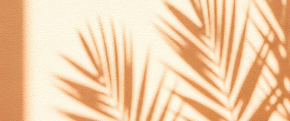 Obraz premium Palm leaves shadows on a beige wall create a tropical and minimalist aesthetic, producing a serene decorative background with natural sunlight, soft textures, and elegant interior visual effect.