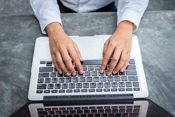 Business documents on office table with smart phone and laptop computer and graph financial with social network diagram and three colleagues discussing data in the background