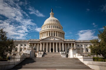 Naklejka premium US Capitol Building under blue sky on sunny day, wide angle panoramic view of government architecture with dome and columns