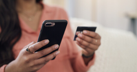 Hands, phone and payment with credit card on sofa for online shopping, deal or discount in home. Person, smartphone and click with e commerce, sale or bills on fintech app with banking at apartment