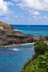Inviting coastline featuring rocky formations and boats sailing in serene waters.