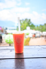 A refreshing melon smoothie on an outdoor wooden table