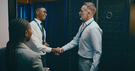 Agreement, handshake and welcome with people in server room for network administration deal. Cybersecurity, meeting and thank you with team shaking hands in data center for tech support collaboration