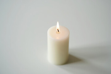 Single glowing candle flickering warm light creates ambiance and serenity