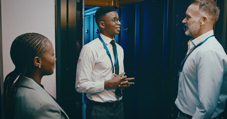 Collaboration, conversation and cybersecurity with people in server room for network...