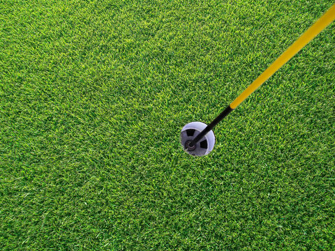 Golf course hole with flag pole, close-up, view from above