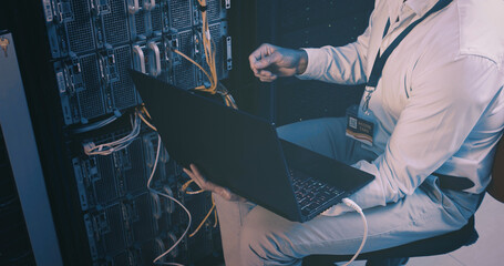 Fixing, cables and hands with laptop, server room and network engineering with tech and electrician. Data center, technician and person with app for software upgrade, troubleshooting and online