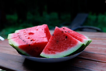 Fresh slices of watermelon on a plate on the wooden table