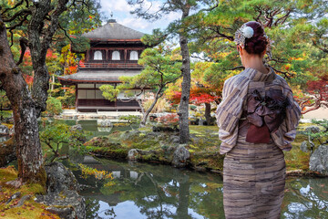Japanese Woman in Traditional Kimono Dress at Ginkaku-ji temple with beautiful foliage in autumn in Kyoto, Japan