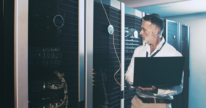 Server room, programmer and man with laptop, inspection and hardware problem solving. IT specialist, mature person or employee with pc, cyber security and tech upgrade with maintenance or control box