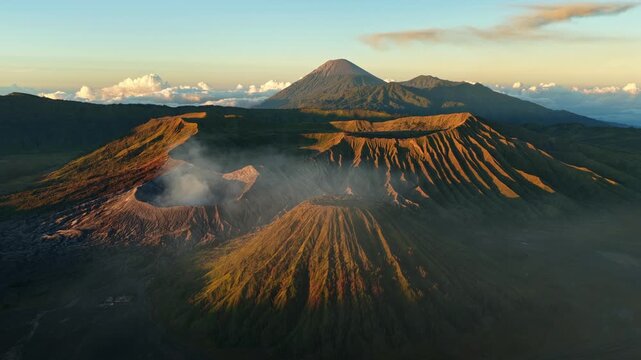 Cinematic drone footage flying toward Mount Bromo at sunrise in East Java, Indonesia. The approach shot highlights the volcano, golden light, and dramatic Tengger Caldera landscape.