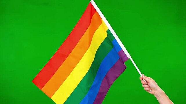 Rainbow pride flag waving against plain green screen background representing LGBTQ+ themes, diversity, equality, activism, and community celebration visual presentations.