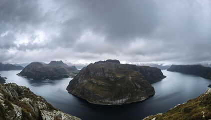 Fototapeta premium A dramatic fjord vista, showcasing rugged mountains and a calm waterway under a dramatic sky.