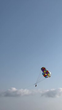 Parasailing water amusement - flying on a parachute behind a boat on a summer holiday by the sea