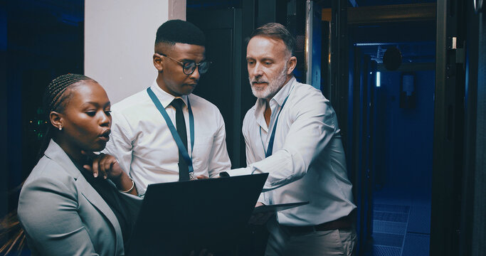 Man, laptop and group with discussion in server room with cybersecurity, system or collaboration. Programmer, tech and team with insight for problem solving, assessment or IT solution at data center - Powered by Adobe