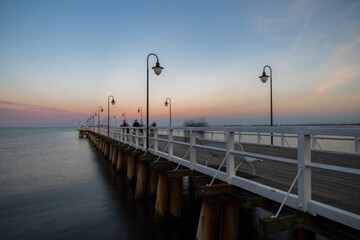 Obraz premium Sunset sky and beautiful old pier on the Baltic Sea in Gdynia, Poland