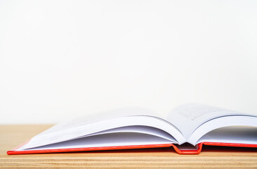 An open book on a wooden shelf and white background