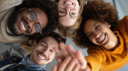 young happy laughing creative team four multicultural coworkers or college students group celebrate success together giving highfive in office classroom top view great teamwork result high five no lo