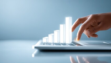 A hand points to a glowing bar graph on a laptop keyboard