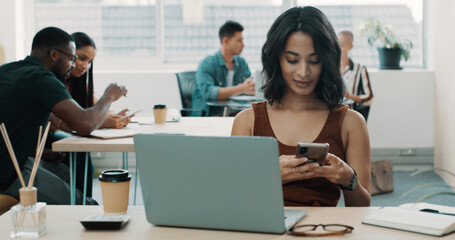 Laptop, phone and businesswoman in office with networking, communication or connectivity. Happy, technology and female editor with cellphone for contact or texting on mobile app on break in workplace