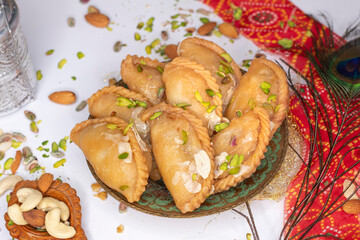 Gujhiya, Indian fried sweet with dry fruits and fancy decorative background