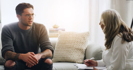 Obraz premium Chat, therapy and people on sofa in counseling session for mental health, assessment and support. Patient report, psychologist diagnosis and treatment plan with man and woman in office for healing