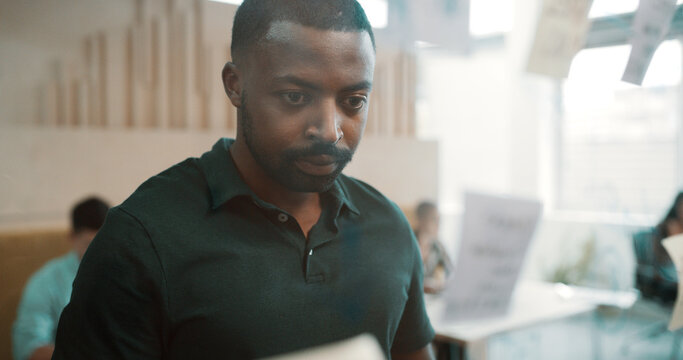 Businessman, thinking or brainstorming with glass board in office for mindmap, ideas or strategy. Sticky note, male person or creative employee contemplating tasks with reminder for agenda or project - Powered by Adobe