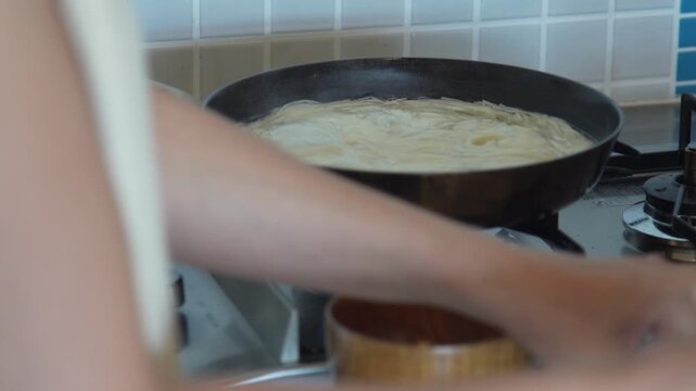 そうめんを茹でる女性