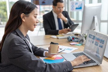 ian businesswoman working with computer laptop and mobile phone in a modern office during a typical workday, representing multitasking, digital communication, and professional lifestyle in a corporate