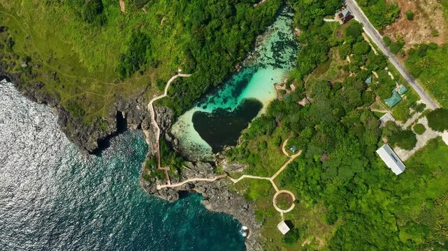 Top down aerial drone descent over Waikuri Lagoon in Sumba, Indonesia. Cinematic view of turquoise waters, surrounding reef, and tropical scenery in this hidden island paradise.