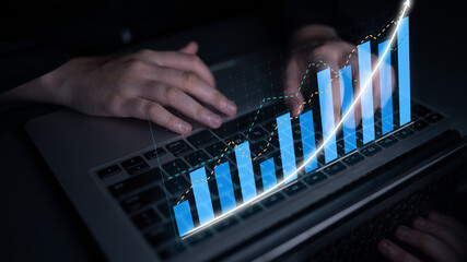 A business professional hands on a laptop display financial data with a glowing bar chart. This image represents growth, analysis, and success in today digital marketplace. Impute