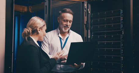 Laptop, collaboration and people with in server room for technical support, database or cybersecurity. Computer, teamwork and technicians with system upgrade in data center for network programming.